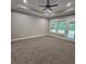 Spacious bedroom featuring plush carpet, tray ceiling, and windows overlooking the backyard at 6093 Wayarer Dr, Villa Rica, GA 30180