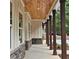 Inviting front porch with wood ceiling, stone accents and timber columns offer a cozy outdoor space at 6093 Wayarer Dr, Villa Rica, GA 30180