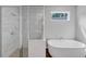 Bathroom featuring a glass shower and soaking tub with a view of the outdoors at 107 Cedar Brook Dr, Canton, GA 30115