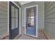 Close-up of the gray front door with glass panels, enhanced by brick accents and modern hardware at 107 Cedar Brook Dr, Canton, GA 30115