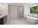 Luxurious bathroom with a soaking tub, a glass-enclosed shower, marble accents, and a stylish vanity at 2432 Whites Rdg, Decatur, GA 30034
