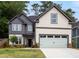 Charming two-story home featuring a stylish gray and cream exterior with a two-car garage and landscaped front yard at 2432 Whites Rdg, Decatur, GA 30034