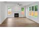 Bright living room with wood floors, a modern fireplace, and large windows offering natural light and backyard views at 2432 Whites Rdg, Decatur, GA 30034