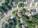 Aerial neighborhood view of homes with mature trees, green lawns and winding streets on a sunny day at 2810 Promenade Pl, Buford, GA 30519