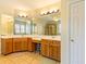 Well-lit bathroom with double vanity, wood cabinets, and tile flooring offering modern comfort at 2810 Promenade Pl, Buford, GA 30519