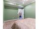This cozy bedroom has carpet, green walls, white trim, with a staircase visible through the open door at 2810 Promenade Pl, Buford, GA 30519