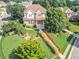 Aerial view of two-story home with manicured landscaping, a covered front porch and mature trees at 2810 Promenade Pl, Buford, GA 30519