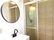 Bathroom with a vanity, round mirror, and shower behind sliding glass doors at 579 Kenridge Cir, Stone Mountain, GA 30083