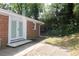Rear exterior view of brick home with double doors leading to patio and yard at 579 Kenridge Cir, Stone Mountain, GA 30083