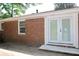 Exterior of a brick house with white-framed double doors and a concrete patio at 579 Kenridge Cir, Stone Mountain, GA 30083