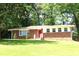 Charming brick home with a bright red front door and manicured lawn at 579 Kenridge Cir, Stone Mountain, GA 30083