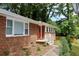 Charming brick home with a red front door, complemented by a neatly landscaped yard and lush green trees at 579 Kenridge Cir, Stone Mountain, GA 30083