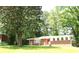 Brick home with red front door framed by mature trees and lush lawn at 579 Kenridge Cir, Stone Mountain, GA 30083