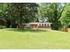 Brick home with bright red front door surrounded by lush greenery at 579 Kenridge Cir, Stone Mountain, GA 30083