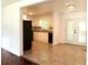 Open kitchen featuring white cabinets, black appliances, tile flooring, and a view of the back yard from the French doors at 579 Kenridge Cir, Stone Mountain, GA 30083