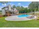 Expansive backyard with a sparkling pool, meticulously landscaped grounds, and a charming covered patio at 65 Millennial Ct, Lawrenceville, GA 30045