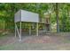Playhouse in a lush backyard featuring a wooden structure, slide, climbing area, surrounded by mature trees at 65 Millennial Ct, Lawrenceville, GA 30045