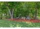 Landscaped backyard with decorative rocks, mulch, and trees, creating a serene and natural outdoor space at 65 Millennial Ct, Lawrenceville, GA 30045