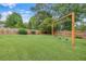 Lush backyard featuring a well-maintained lawn, wooden swing set, and a privacy fence, perfect for Gathering enjoyment at 65 Millennial Ct, Lawrenceville, GA 30045
