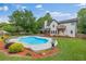 Spacious backyard showcasing a sparkling pool, lush landscaping, and a covered patio for outdoor enjoyment at 65 Millennial Ct, Lawrenceville, GA 30045