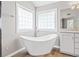 Bright bathroom featuring a modern tub, tiled windows, and a single vanity at 65 Millennial Ct, Lawrenceville, GA 30045