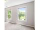 Bright carpeted bedroom with two windows overlooking the backyard at 65 Millennial Ct, Lawrenceville, GA 30045