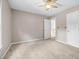 Spacious bedroom with neutral paint, ceiling fan and carpet flooring, and an open door at 65 Millennial Ct, Lawrenceville, GA 30045