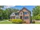 Beautifully maintained brick home featuring a manicured front lawn and mature shrubbery, complemented by black window shutters at 65 Millennial Ct, Lawrenceville, GA 30045