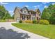 Traditional brick home with attached garage and spacious front lawn, complemented by mature trees and manicured shrubbery at 65 Millennial Ct, Lawrenceville, GA 30045