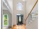 Grand two-story foyer with hardwood floors, a staircase, and a large window that floods the space with natural light at 65 Millennial Ct, Lawrenceville, GA 30045