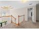 Open landing with chandelier, wood railing, and ample natural light at 65 Millennial Ct, Lawrenceville, GA 30045