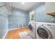 Functional laundry room with washer, dryer, and storage shelving at 65 Millennial Ct, Lawrenceville, GA 30045