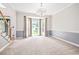 Bright, neutral living room with plush carpeting, large windows, and elegant chandelier at 65 Millennial Ct, Lawrenceville, GA 30045