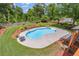 Aerial view of sparkling in-ground pool with mature landscaping and a private fenced in yard at 65 Millennial Ct, Lawrenceville, GA 30045