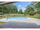 Beautiful backyard featuring a sparkling pool, lush landscaping, and a spacious deck perfect for outdoor entertaining at 65 Millennial Ct, Lawrenceville, GA 30045