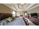 A spacious main bedroom features a tray ceiling, a king bed, a dresser, and an open door to ensuite bathroom at 208 Eagles Flight, Villa Rica, GA 30180