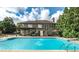 Backyard oasis featuring a large swimming pool, covered patio, outdoor seating, and landscaped surroundings at 208 Eagles Flight, Villa Rica, GA 30180