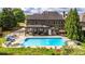 Expansive backyard highlighting a pool, lounge seating, covered patio, and a beautifully maintained lawn at 208 Eagles Flight, Villa Rica, GA 30180
