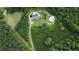 Aerial view of a property with a house, pool, barn, and extensive surrounding forest at 2997 Happy Hollow Se Dr, Conyers, GA 30094