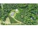 Expansive aerial view of a secluded property surrounded by lush greenery, featuring a pool and long private driveway at 2997 Happy Hollow Se Dr, Conyers, GA 30094