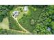Overhead view of a private property with a house, pool, and a winding driveway through dense, green trees and foliage at 2997 Happy Hollow Se Dr, Conyers, GA 30094
