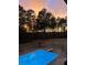 Gorgeous backyard with a refreshing pool and a serene treeline as a backdrop at sunset at 2997 Happy Hollow Se Dr, Conyers, GA 30094