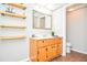 Bathroom with a vanity, a mirror, open floating shelves, and earth-toned tile flooring at 2997 Happy Hollow Se Dr, Conyers, GA 30094