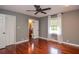 This bedroom features hardwood floors, a ceiling fan, a window, and an ensuite bathroom at 2997 Happy Hollow Se Dr, Conyers, GA 30094
