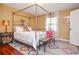 Bright bedroom with a four-poster bed, hardwood floors, and patterned rug at 2997 Happy Hollow Se Dr, Conyers, GA 30094