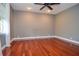 This bedroom features hardwood floors, a ceiling fan, a window, and fresh paint at 2997 Happy Hollow Se Dr, Conyers, GA 30094