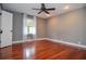 This bedroom features hardwood floors, a ceiling fan, a window, and fresh paint at 2997 Happy Hollow Se Dr, Conyers, GA 30094