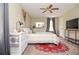 Bright bedroom featuring a ceiling fan, bedside table, and a cozy rug at 2997 Happy Hollow Se Dr, Conyers, GA 30094