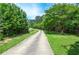 Long, winding driveway leading to a secluded property surrounded by lush greenery at 2997 Happy Hollow Se Dr, Conyers, GA 30094