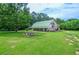 Spacious home exterior with green roof, side deck, and surrounded by lush greenery at 2997 Happy Hollow Se Dr, Conyers, GA 30094